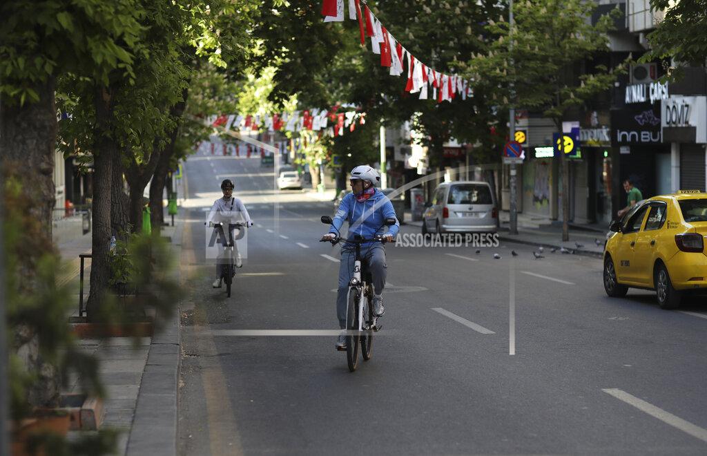 Burhan Ozbilici People ride bicycles on a deserted road during a lockdown, in Ankara, Turkey, Saturday, May 15, 2021. Turkey is in the final days of a full lockdown and the government has ordered people to stay home and businesses to close amid a huge surge in infections. But millions of workers are exempt and so are foreign tourists. (AP Photo/Burhan Ozbilici)