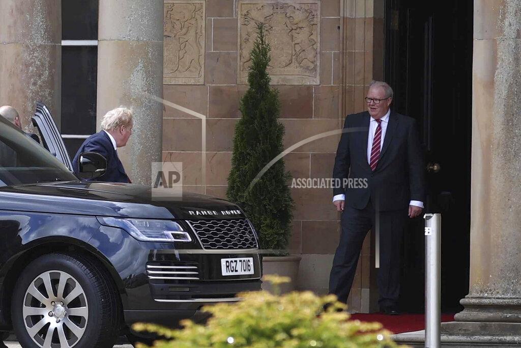 Liam Mcburney British Prime Minister Boris Johnson, left, gets out of a car as he is welcomed by Mark Larmour from the Northern Ireland Office upon his arrival at Hillsborough Castle, Northern Ireland, Monday, May 16, 2022. Johnson on Monday renewed British threats to break a Brexit agreement with the European Union, blaming it for a political crisis that's blocking the formation of a new government in Northern Ireland. (Liam McBurney/PA Wire/PA via AP)