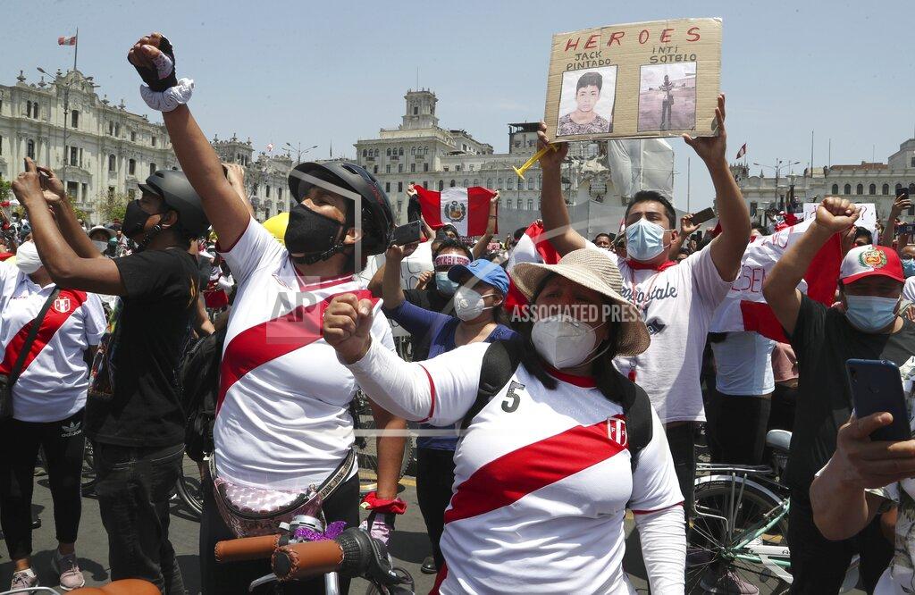 Martin Mejia A person holds a sign with photos of two demonstrators killed during protests as people celebrate the resignation of interim president Manuel Merino, at the Plaza San Martin in Lima, Peru, Sunday, Nov. 15, 2020. Peru’s interim president stepped down following massive protests unleashed when Congress ousted President Martin Vizcarra. (AP Photo/Martin Mejia)
