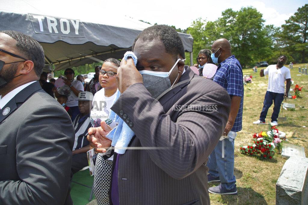 Allen G. Breed Funeral director Shawn Troy wipes away perspiration during a graveside service at Hillcrest Cemetery outside Mullins, S.C., on Monday, May 24, 2021. His father, William Penn Troy Sr., died of COVID-19 in August 2020, one of many Black morticians to succumb during the pandemic. (AP Photo/Allen G. Breed)