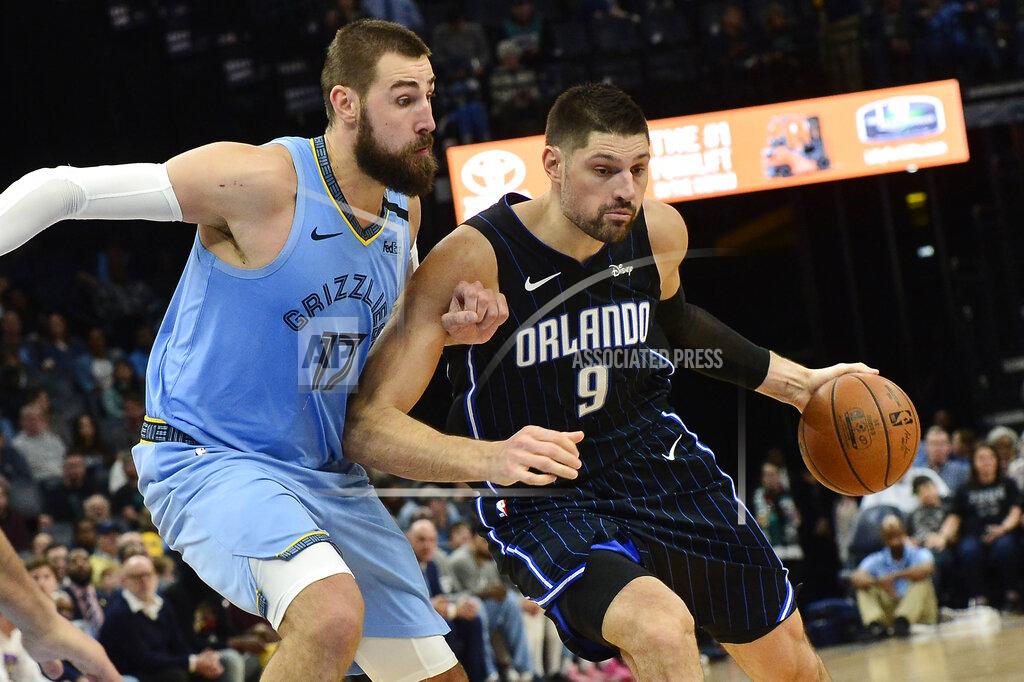 Brandon Dill Orlando Magic center Nikola Vucevic (9) is defended by Memphis Grizzlies center Jonas Valanciunas (17) during the second half of an NBA basketball game Tuesday, March 10, 2020, in Memphis, Tenn. (AP Photo/Brandon Dill)