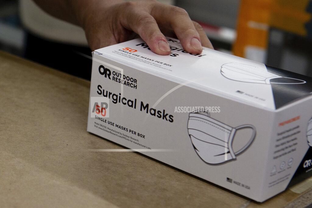 Gerardo Villalobos In this undated photo provided by Outdoor Research in September 2020, a worker moves a box of surgical masks made by the company as they are manufactured and packaged in Seattle. Hospital administrators say they can’t get as many masks as they want, and the FDA included N95s on its most recent medical supply shortage list. (Gerardo Villalobos/Outdoor Research via AP)