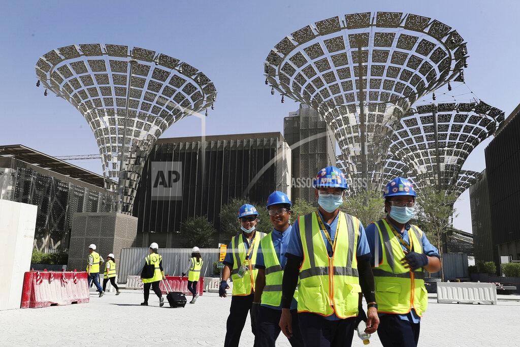 FILE - In this Oct. 8, 2019, file photo, technicians walk at the under construction site of the Expo 2020 in Dubai, United Arab Emirates. Dubai's Expo 2020 world's fair will be postponed to Oct. 1, 2021, over the new coronavirus pandemic, a Paris-based body behind the events said Monday, May 4, 2020. (AP Photo/Kamran Jebreili, File)