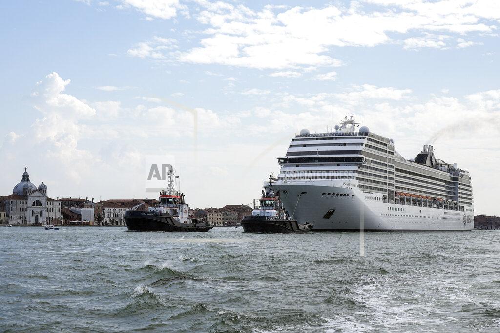 Antonio Calanni The MSC Orchestra cruise ship leaves Venice, Italy, Saturday, June 5, 2021. The 92,409-ton, 16-deck MSC Orchestra cruise ship, the first cruise ship leaving Venice since the pandemic, is set to depart Saturday amid protests by activists demanding that the enormous ships be permanently rerouted out the fragile lagoon, especially Giudecca Canal through the city's historic center, due to environmental and safety risks. The ship passed two groups of protesters: pro-cruise advocates whose jobs depend on the industry as well as protesters who have been campaigning for years to get cruise ships out of the lagoon. (AP Photo/Antonio Calanni)