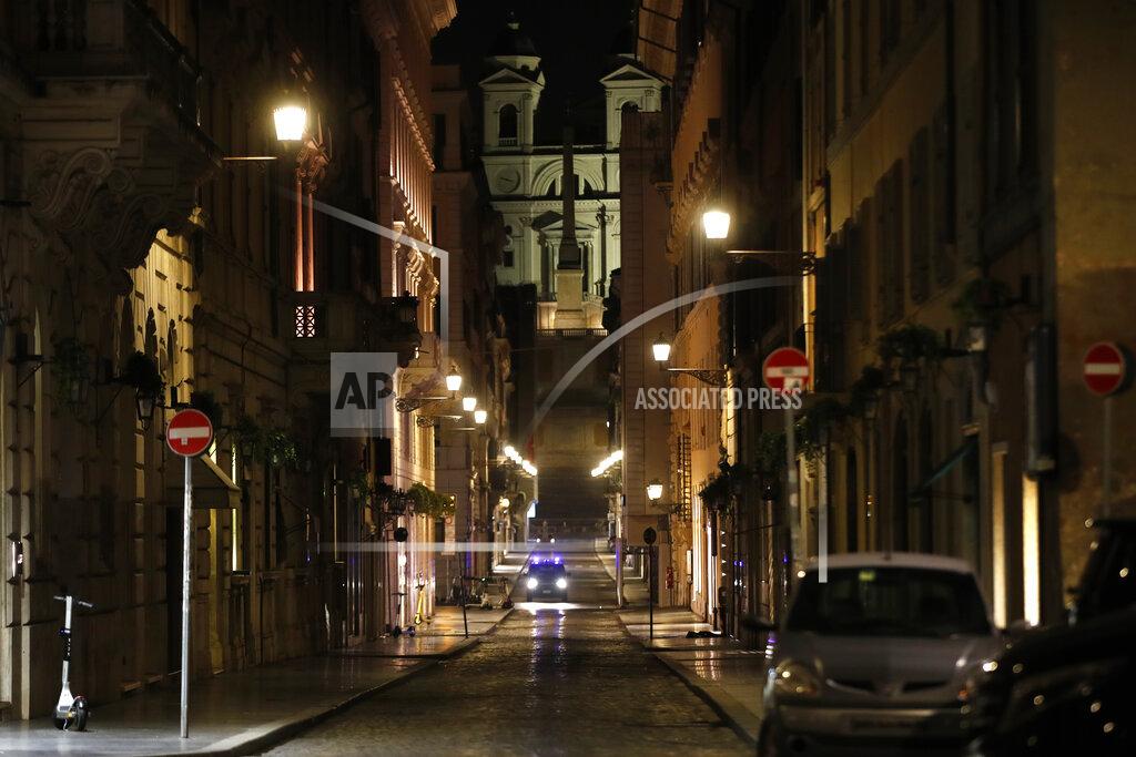 Alessandra Tarantino An Italian Carabinieri paramilitary police car patrols an empty street leading to the Spanish Steps and Trinita' dei Monti Church Rome, early Monday, Oct. 26, 2020. Since midnight last Friday and for the next 30 days, people in Lazio are not allowed to leave their homes from midnight to 5 a.m. daily, except to go to or return from work or for other urgent reasons such as health issues. (AP Photo/Alessandra Tarantino)