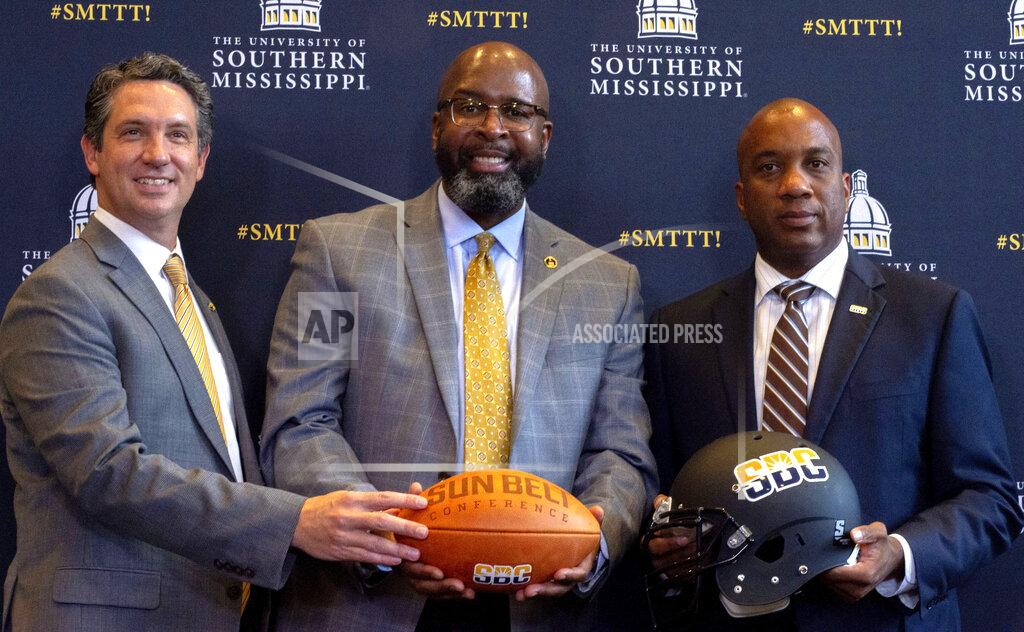 Dominic Gwinn From left: Southern Miss Athletic Director Jeremy McClain, Southern Miss President Dr. Rodney D. Bennett and Sun Belt Conference Commissioner Keith Gill pose for a photo after the university announced it was joining the NCAA Sun Belt Conference at the Southern Miss Trent Lott Center in Hattiesburg, Miss. on Tuesday, Oct. 26, 2021. (Dominic Gwinn/Hattiesburg American via AP)