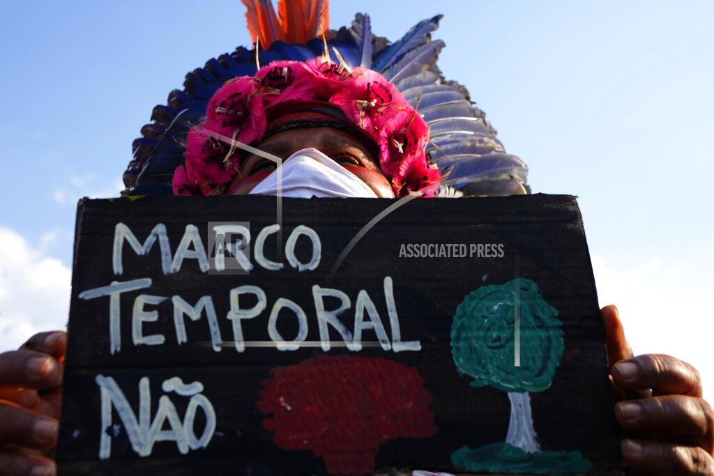 Eraldo Peres An Indigenous woman shows sign written in Portuguese that reads "Timeframe No", after the Supreme Court judges' decision to suspend the vote that defines the demarcation of Indigenous lands, during a protest in front of the Supreme Court building, in Brasilia, Brazil, Wednesday, Sept. 15, 2021. (AP Photo/Eraldo Peres)