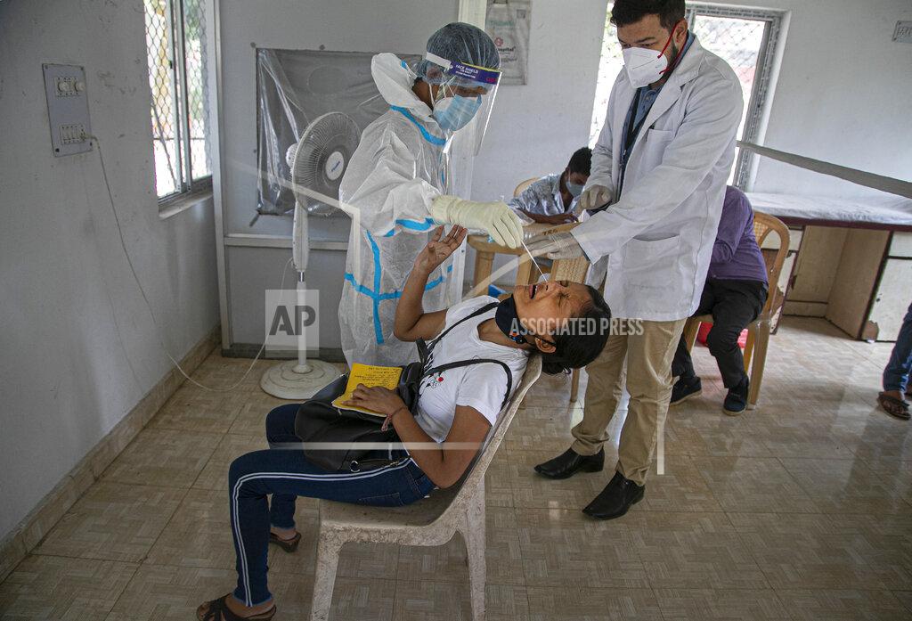 Anupam Nath A health worker takes a nasal swab sample of a girl to test for COVID-19 during a random test for the family members of army personnel at the army base hospital in Gauhati, India, Monday, Oct. 19, 2020. (AP Photo/Anupam Nath)
