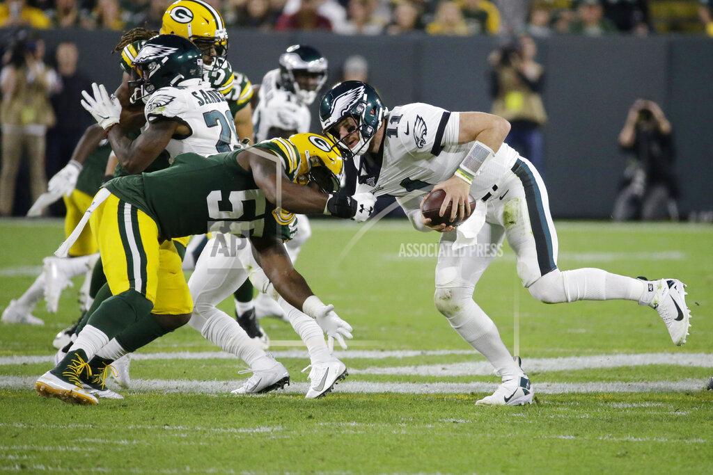 Mike Roemer Philadelphia Eagles quarterback Carson Wentz scrambles to break free from the defense of Green Bay Packers outside linebacker Za'Darius Smith during the first half of an NFL football game Thursday, Sept. 26, 2019, in Green Bay, Wis. (AP Photo/Mike Roemer)