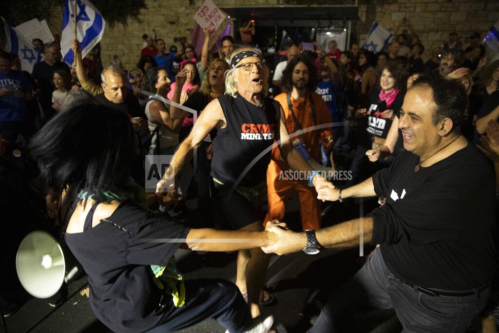 Ariel Schalit Israeli protesters dance and cheer during a demonstration against Israeli Prime Minister Benjamin Netanyahu outside his official residence in Jerusalem, Saturday, June 12, 2021. If all goes according to plan, Israel will swear in a new government on Sunday, ending Prime Minister Benjamin Netanyahu's record 12-year rule and a political crisis that inflicted four elections on the country in less than two years. (AP Photo/Ariel Schalit)
