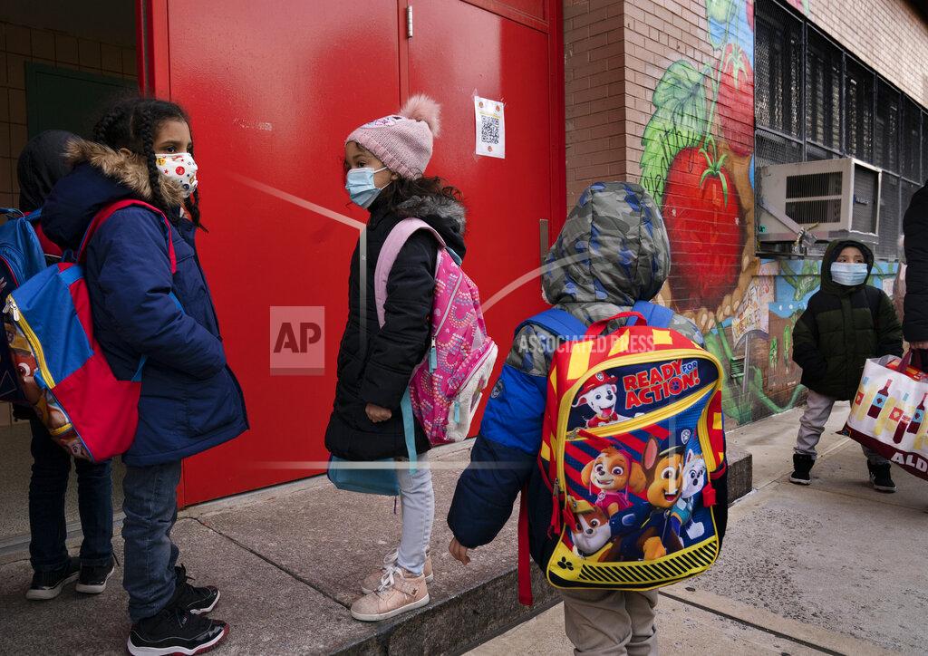 Mark Lennihan Students enter P.S. 134 Henrietta Szold Elementary School, Monday, Dec. 7, 2020, in New York. Public schools reopened for in-school learning Monday after being closed since mid-November. (AP Photo/Mark Lennihan)