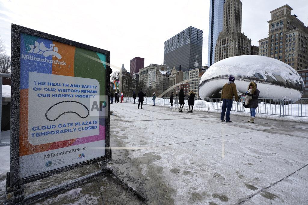 Nam Y. Huh A sign advises that the area immediately around the Cloud Gate sculpture at Millennium Park in Chicago is closed during the coronavirus pandemic, on a cold winter's day Sunday, Feb. 14, 2021. (AP Photo/Nam Y. Huh)