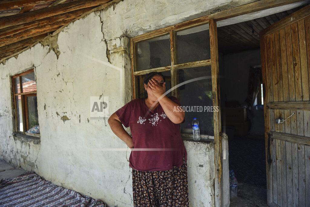 Uncredited A woman reacts as she watches wildfires in Kacarlar village near the Mediterranean coastal town of Manavgat, Antalya, Turkey, Saturday, July 31, 2021. The death toll from wildfires raging in Turkey's Mediterranean towns rose to six Saturday after two forest workers were killed, the country's health minister said. Fires across Turkey since Wednesday burned down forests, encroaching on villages and tourist destinations and forcing people to evacuate. (AP Photo)