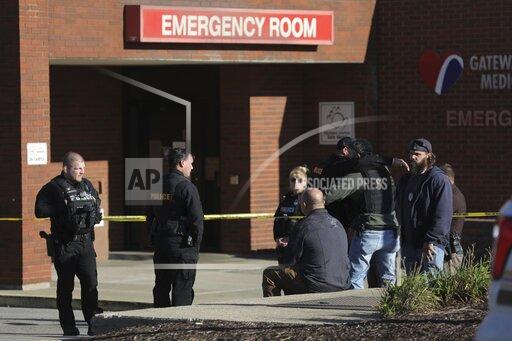 ADDS THAT POLICE OFFICER HAS DIED - Police officers embrace while waiting outside the emergency room at Gateway Medical Center in Granite City, Ill., on Tuesday, Oct. 26, 2021. A police officer died Tuesday after being shot by a man at gas station in an Illinois suburb of St. Louis, authorities said. (Colter Peterson/St. Louis Post-Dispatch via AP)