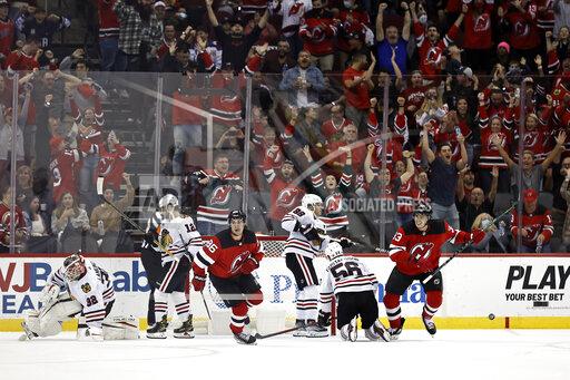 New Jersey Devils center Jack Hughes (86) celebrates after scoring past Chicago Blackhawks goaltender Kevin Lankinen (32) in overtime of an NHL hockey game Friday, Oct. 15, 2021, in Newark, N.J. The Devils won 4-3. (AP Photo/Adam Hunger)