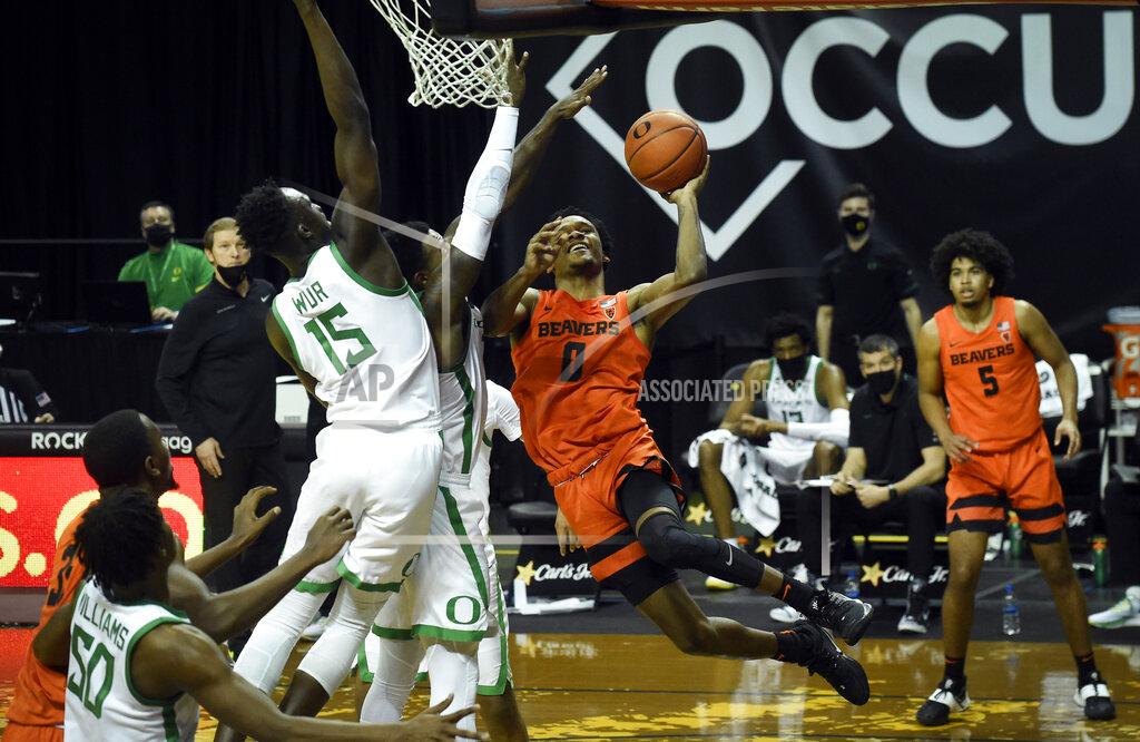 Andy Nelson Oregon State guard Gianni Hunt (0) drives to the basket as Oregon forward Lok Wur (15) defends on the play during the first half of an NCAA college basketball game Saturday, Jan. 23, 2021, in Eugene, Ore. (AP Photo/Andy Nelson)