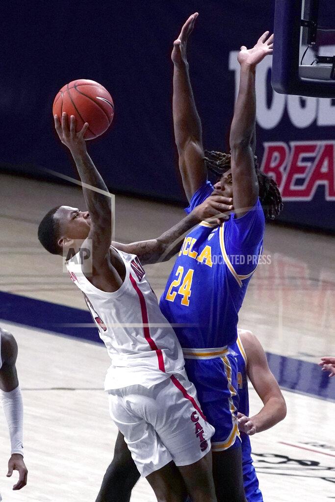 Rick Scuteri Arizona guard James Akinjo drives on UCLA forward Jalen Hill (24) during the first half of an NCAA college basketball game Saturday, Jan. 9, 2021, in Tucson, Ariz. (AP Photo/Rick Scuteri)