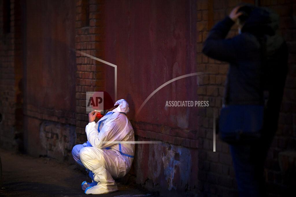 Andreea Alexandru An emergency paramedic leans against a wall outside the Matei Bals hospital compound in Bucharest, Romania, Friday, Jan. 29, 2021. A fire early Friday at a key hospital in Bucharest that also treats COVID-19 patients killed four people, authorities said. (AP Photo/Andreea Alexandru)