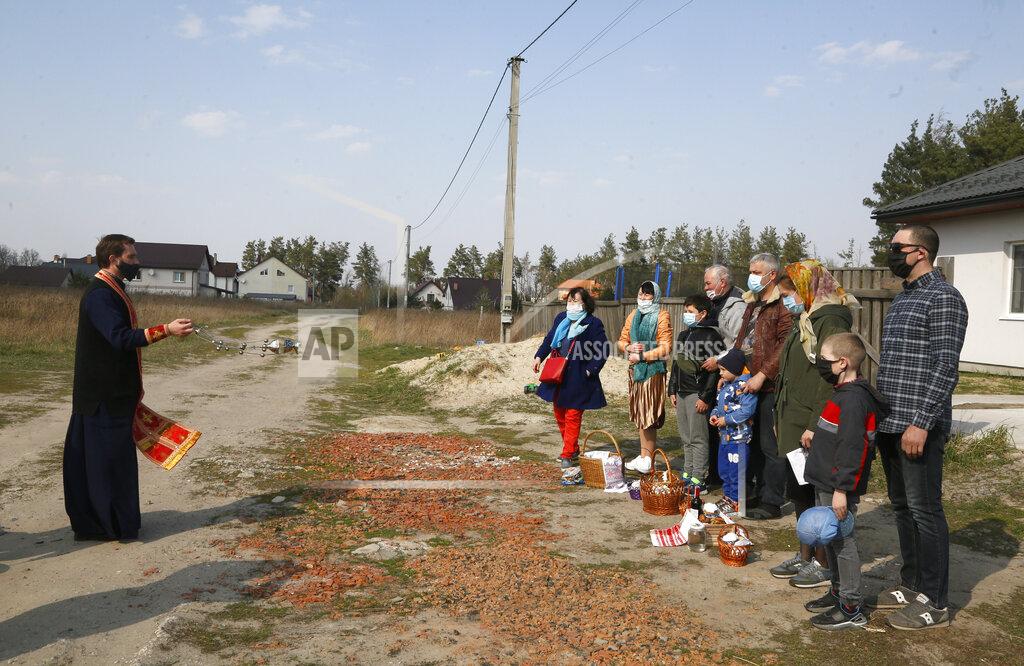 Efrem Lukatsky A priest of the Ukrainian Orthodox Church Nazariy, wearing a face mask to protect against coronavirus, blesses family members on the Easter eve near their house in the village of Nove close to capital Kyiv, Ukraine, Saturday, April, 18, 2020. All the Ukrainian churches have been closed for people because of COVID-19 outbreak, and believers wait for the priest right near their houses. For Orthodox Christians, this is normally a time of reflection, communal mourning and joyful release, of centuries-old ceremonies steeped in symbolism and tradition. But this year, Easter - by far the most significant religious holiday for the world's roughly 300 million Orthodox - has essentially been cancelled. (AP Photo/Efrem Lukatsky)