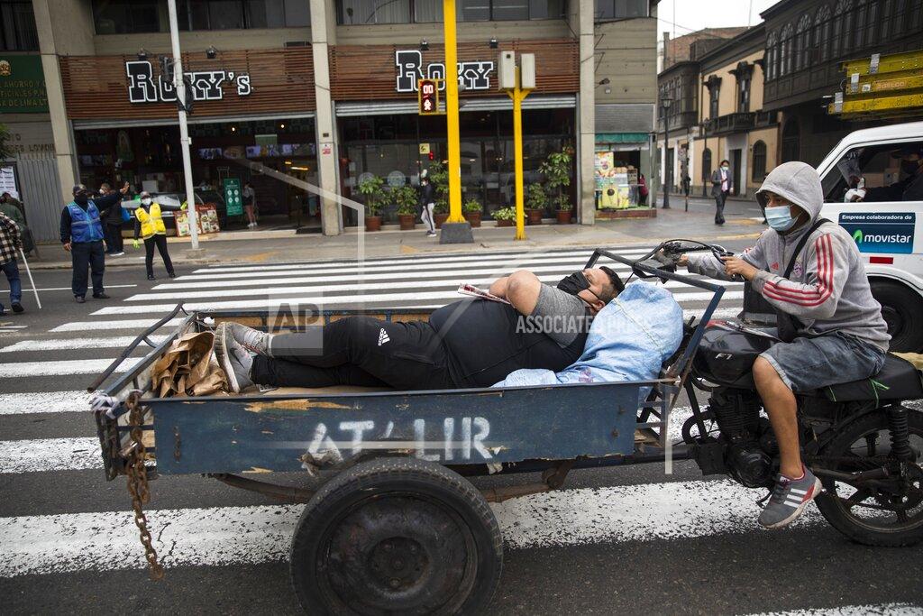 Rodrigo Abd A commuter rests on the flatbed of a motorbike that will take him to work, a block away from the Congress in Lima, Peru, Friday, Sept. 18, 2020. A high Peruvian court rejected a request by President Martín Vizcarra Thursday to halt impeachment proceedings being pushed by opposition lawmakers who contend he tried to cover up ties with a controversial ally. (AP Photo/Rodrigo Abd)