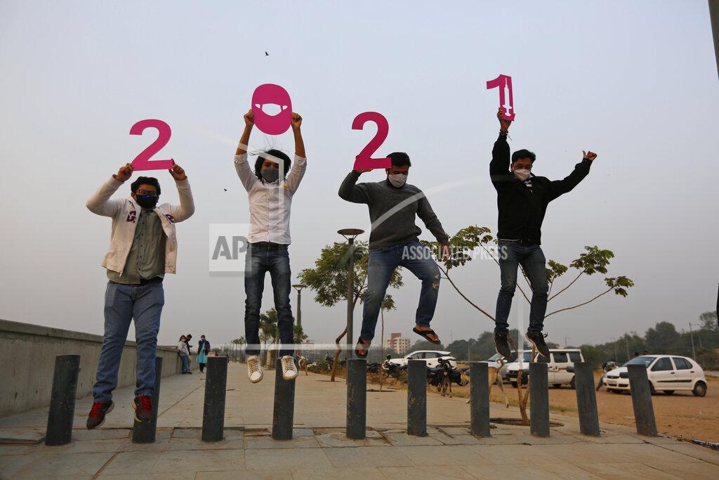 Ajit Solanki People hold cutouts to welcome the New Year in Ahmedabad, India, Thursday, Dec. 31, 2020. (AP Photo/Ajit Solanki)