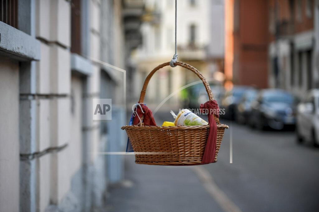 Claudio Furlan One of the baskets with food and other goods hanging from balconies and left at disposition of people in need during the coronavirus emergency in Milan, Italy, Saturday, April 4, 2020. The initiative, dubbed "hanging baskets", was born after an old Neapolitan tradition, that of the "hanging coffee" (Caffe' sospeso) that customers pay in bars and are left at disposition of whoever enters the bar and asks for it. The new coronavirus causes mild or moderate symptoms for most people, but for some, especially older adults and people with existing health problems, it can cause more severe illness or death. (Claudio Furlan/LaPresse via AP)
