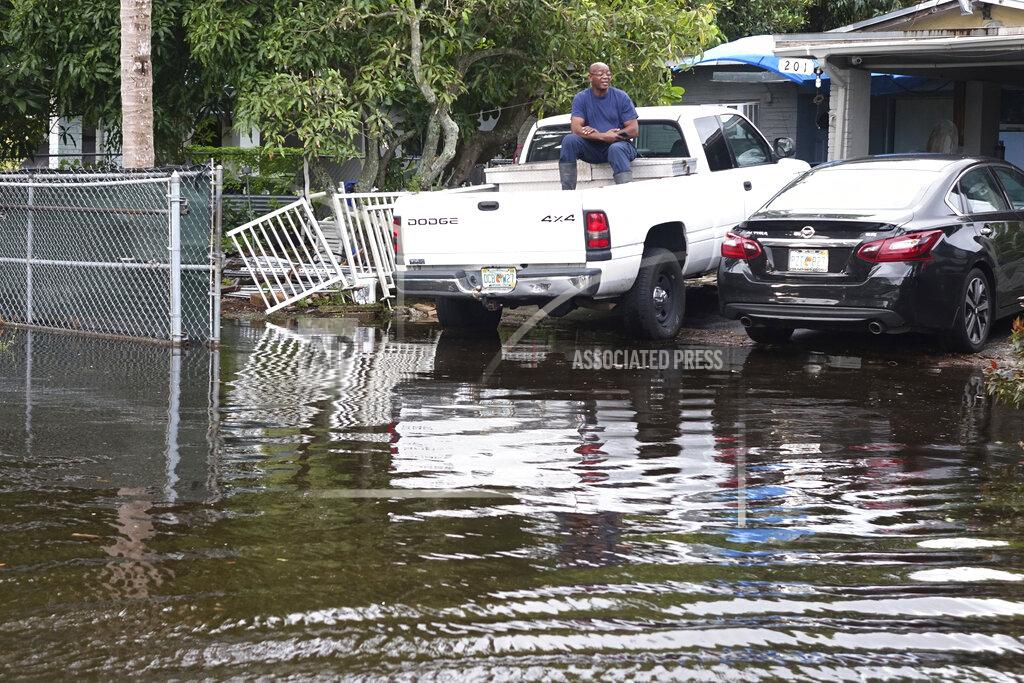 Joe Cavaretta Rance Ford watches a passing vehicle on his flooded street in Melrose Manors in Fort Lauderdale, Fla. Monday, Nov. 9, 2020. Tropical Storm Eta dumped rain as it passed over South Florida streets flooded. (Joe Cavaretta/South Florida Sun-Sentinel via AP)