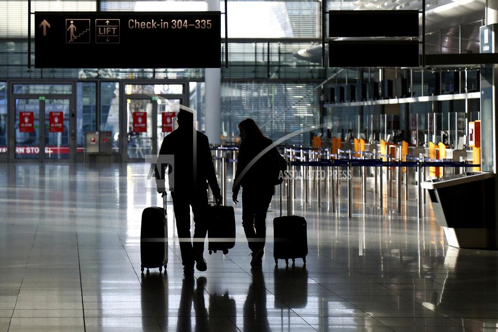 Matthias Schrader FILE - In this Saturday, Dec. 26, 2020 file photo, people walk with their luggage through a deserted check-in hall at the airport in Munich, Germany as Germany continues its second lockdown to avoid the further outspread of the coronavirus. On Tuesday, Jan. 12, 2021, the U.S. government said it will require airline passengers entering the country to show proof of a negative COVID-19 test before boarding their flights. It will take effect Jan. 26. (AP Photo/Matthias Schrader)