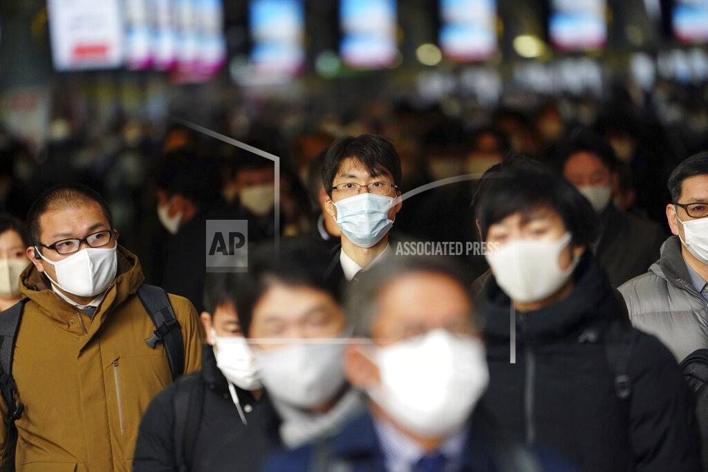 Eugene Hoshiko Some people commute on the first business day of the year at a train station Monday, Jan. 4, 2021, in Tokyo. Japanese Prime Minister Yoshihide Suga said Monday vaccine approval was being speeded up and border controls beefed up to curb the spread of the coronavirus, and he promised to consider declaring a state of emergency.(AP Photo/Eugene Hoshiko)
