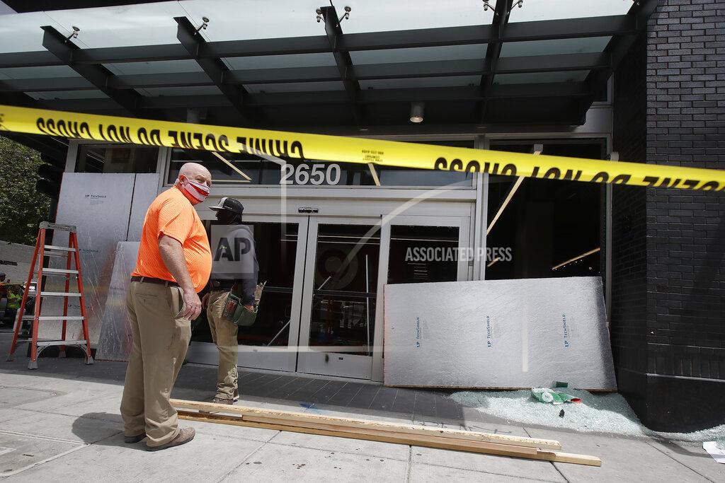 Jeff Chiu People work outside a Target store damaged from protests over the Memorial Day death of George Floyd, a handcuffed black man in police custody in Minneapolis, in Oakland, Calif., Saturday, May 30, 2020. (AP Photo/Jeff Chiu)