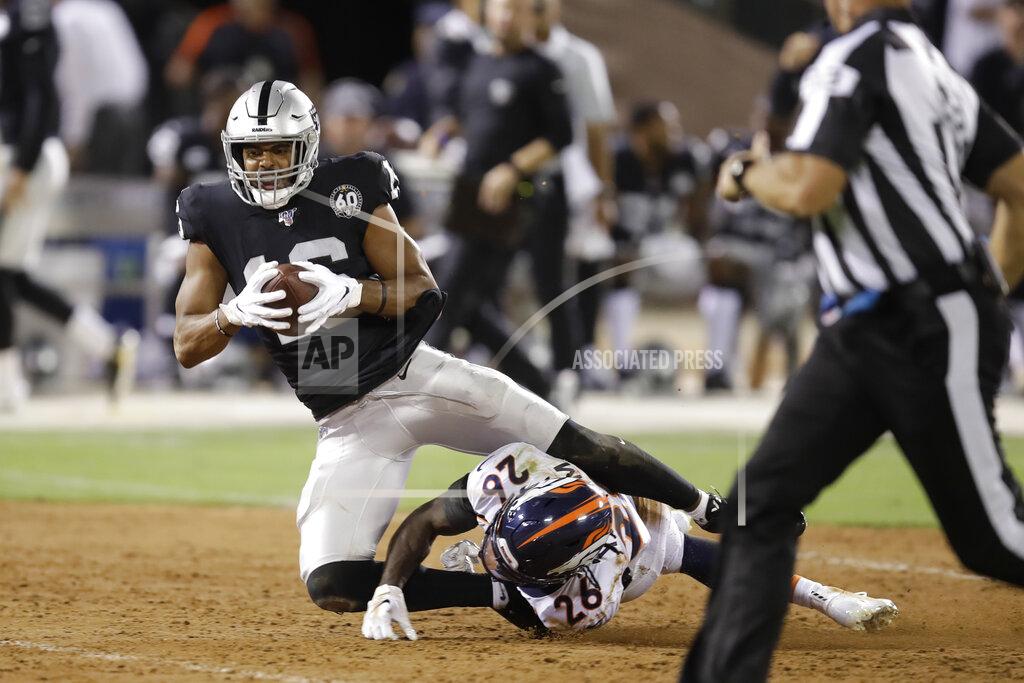 Ben Margot Oakland Raiders wide receiver Tyrell Williams tumbles over Denver Broncos cornerback Isaac Yiadom (26) after making a reception during the first half of an NFL football game Monday, Sept. 9, 2019, in Oakland, Calif. (AP Photo/Ben Margot)