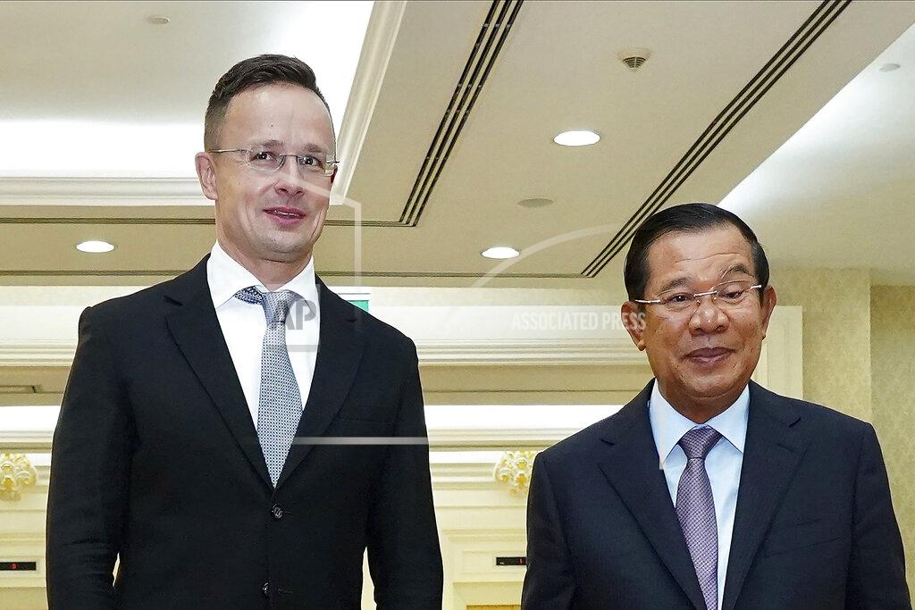 Hungarian Foreign Minister Peter Szijjarto, left, poses with Cambodian Prime Minister Hun Sen for a photo prior to a meeting at Peace Palace in Phnom Penh, Cambodia, Tuesday, Nov. 3, 2020. Szijjarto tested positive for the coronavirus after arriving in Thailand for an official visit, Thai and Hungarian officials said Wednesday, Nov. 4, 2020. (Pool Photo via AP)