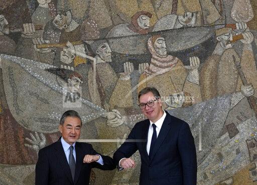 Chinese Foreign Minister Wang Yi, left, elbow bumps with Serbian President Aleksandar Vucic after a news conference at the Serbia Palace in Belgrade, Serbia, Thursday, Oct. 28, 2021. Wang Yi is on a two-day official visit to Serbia. (AP Photo/Darko Vojinovic)