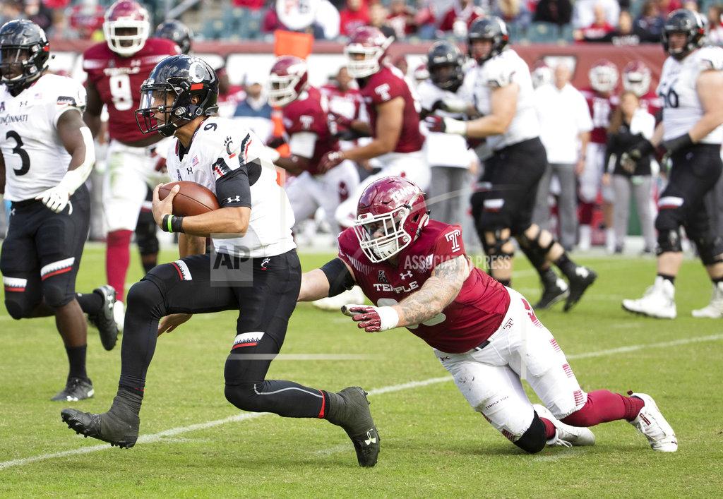 Chris Szagola Cincinnati's quarterback Desmond Ridder (9) scrambles past Temple's defensive end Jimmy Hogan (98) during the second half of an NCAA college football, Saturday, Oct. 20, 2018, in Philadelphia. Temple won 24-17 in overtime. (AP Photo/Chris Szagola)