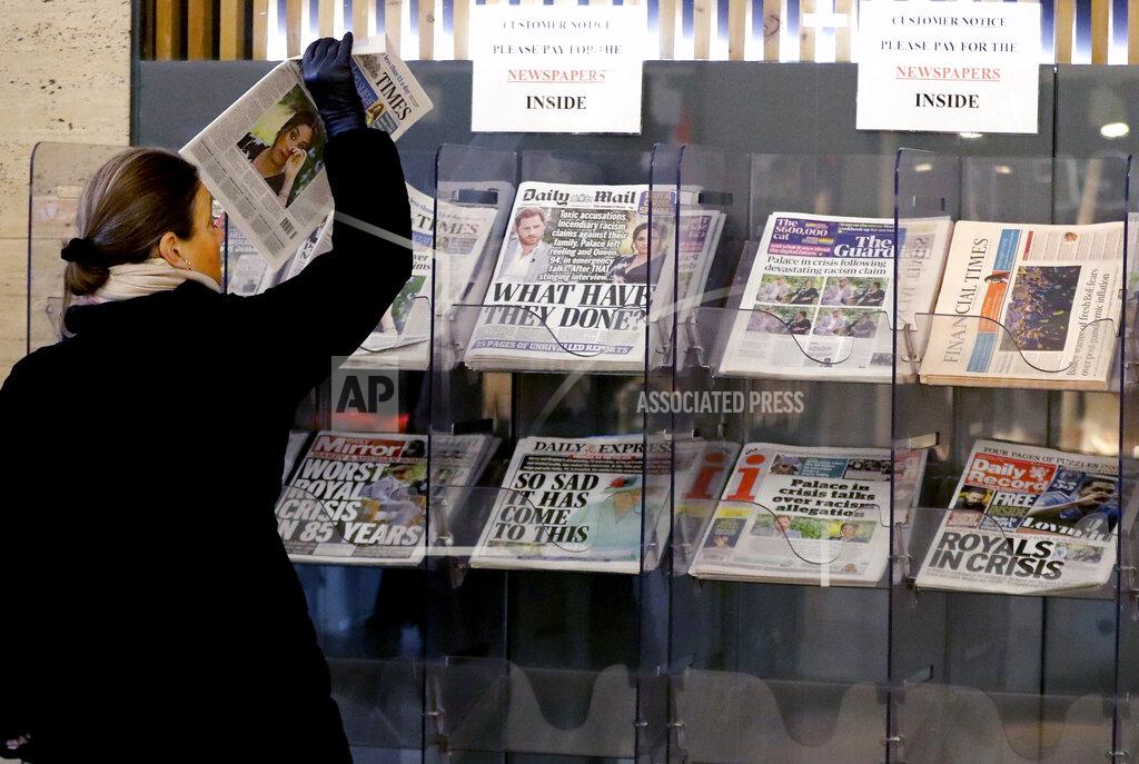 Frank Augstein A customer takes a copy of a newspaper headlining Prince Harry and Meghan’s explosive TV interview at a newspaper stand outside a shop in London, Tuesday, March 9, 2021. Britain's royal family is absorbing the tremors from a sensational television interview by Prince Harry and the Duchess of Sussex, in which the couple said they encountered racist attitudes and a lack of support that drove Meghan to thoughts of suicide. (AP Photo/Frank Augstein)
