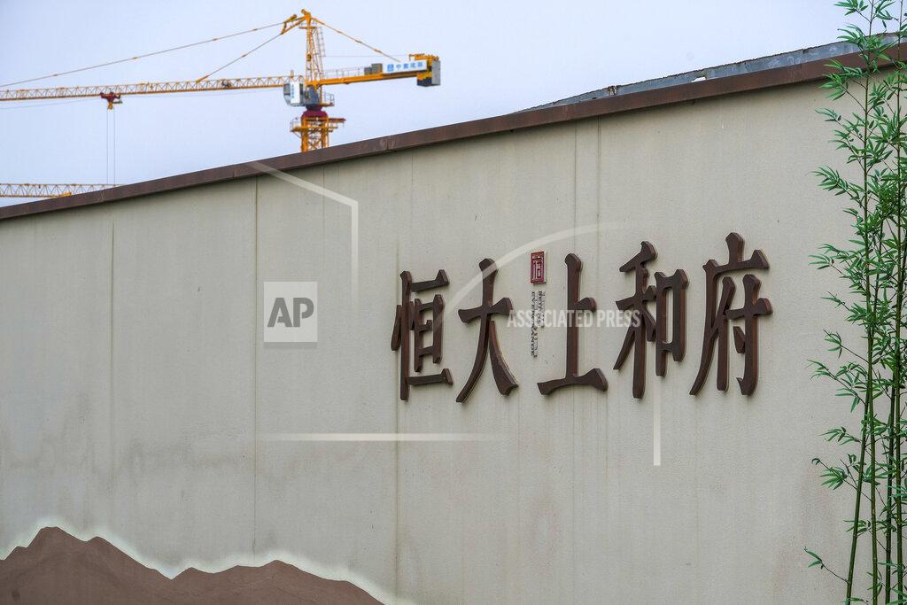 Andy Wong A construction crane stands on a new housing development project by Evergrande in Beijing, Wednesday, Sept. 15, 2021. One of China's biggest real estate developers is struggling to avoid defaulting on billions of dollars of debt, prompting concern about the broader economic impact and protests by apartment buyers about delays in completing projects. Rating agencies say Evergrande Group appears likely to be unable to repay all of the 572 billion yuan ($89 billion) it owes banks and other bondholders. That might jolt financial markets, but analysts say Beijing is likely to step in to prevent wider damage. (AP Photo/Andy Wong)