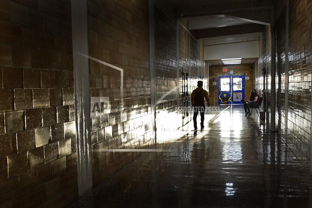 Charlie Riedel A student walks between classes at Wyandotte High School in Kansas City, Kan., on the first day of in-person learning Wednesday, March 30, 2021. The school, like other schools nationwide, has made extra efforts to keep kids at risk of dropping out engaged as classes went virtual due to the pandemic. (AP Photo/Charlie Riedel)