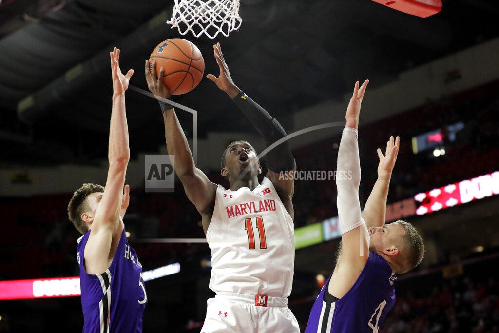Julio Cortez Maryland guard Darryl Morsell (11) goes up for a shot against Holy Cross forward Connor Niego, left, and guard Austin Butler during the first half of an NCAA college basketball game, Tuesday, Nov. 5, 2019, in College Park, Md. (AP Photo/Julio Cortez)