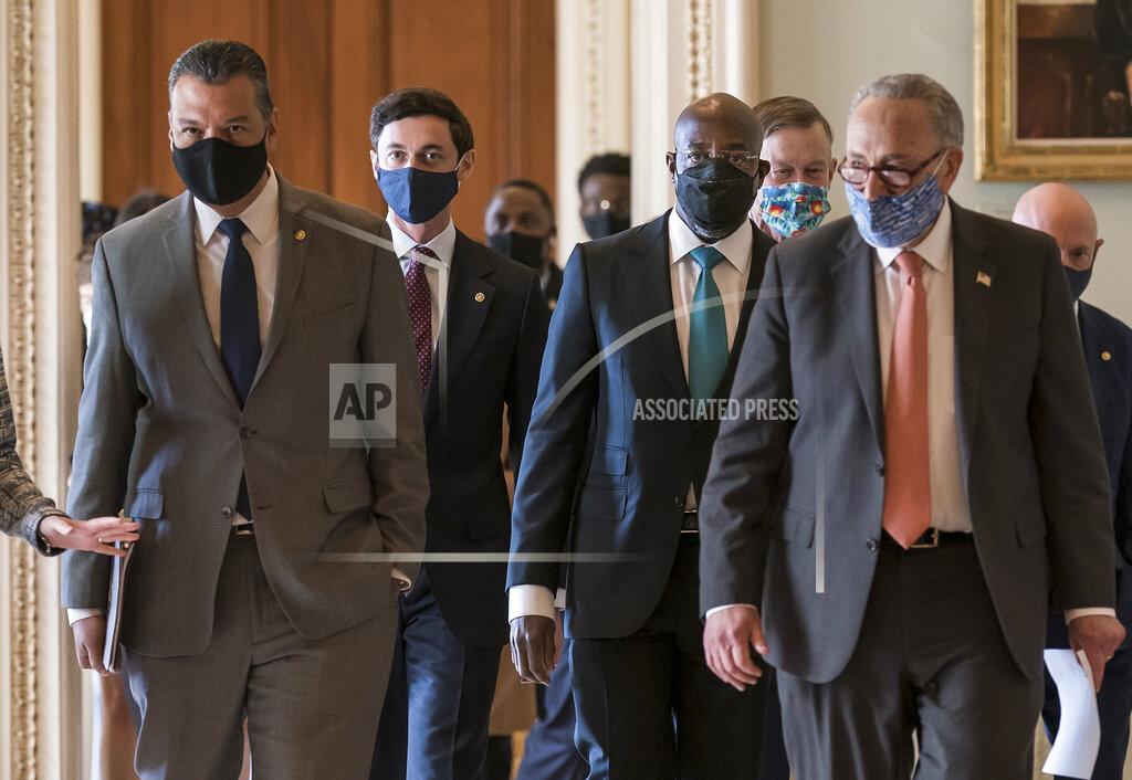 J. Scott Applewhite On the first full day of the Democratic majority in the Senate, new members walk to a news conference with Senate Majority Leader Chuck Schumer, D-N.Y., front right, at the Capitol in Washington, Thursday, Jan. 21, 2021. From left are, Sen. Alex Padilla, D-Calif., who took the seat vacated by Vice President Kamala Harris, Sen. Jon Ossoff, D-Ga., Sen. Raphael Warnock, D-Ga., Sen. John Hickenlooper, D-Colo., Sen. Chuck Schumer, D-N.Y., and Sen. Mark Kelly, D-Ariz. (AP Photo/J. Scott Applewhite)
