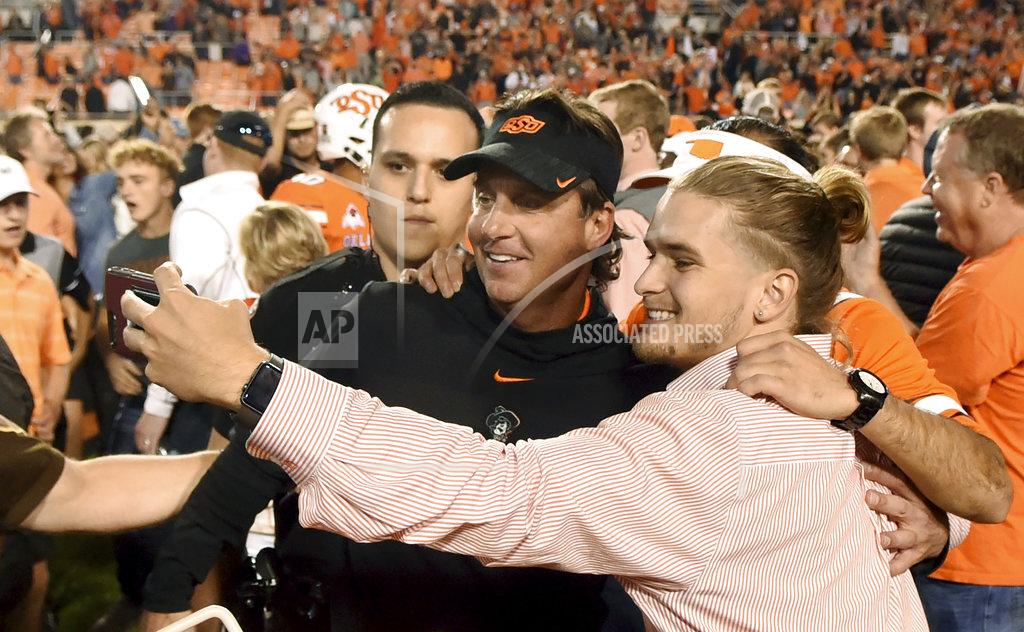 Brody Schmidt Oklahoma State head coach Mike Gundy takes a photo with fans following an NCAA college football game in Stillwater, Okla., Saturday, Oct. 27, 2018. Oklahoma State defeated Texas 38-35. (AP Photo/Brody Schmidt)