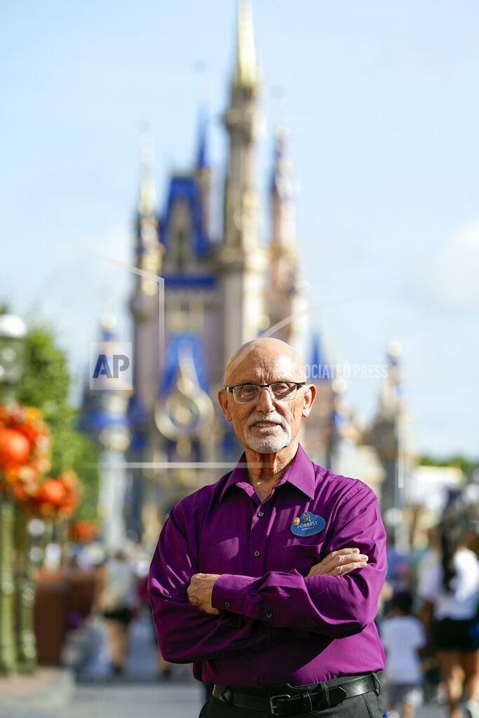 John Raoux Forrest Bahruth stands on Main Street in front of the Cinderella Castle at the Magic Kingdom theme park at Walt Disney World Monday, Aug. 30, 2021, in Lake Buena Vista, Fla. Bahruth has been working at Disney since the opening day in 1971. (AP Photo/John Raoux)