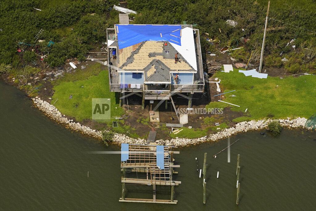 Matt Slocum In this aerial photo, men work on the roof of a damaged home in the aftermath of Hurricane Ida, Monday, Sept. 6, 2021, in Golden Meadow, La. (AP Photo/Matt Slocum)