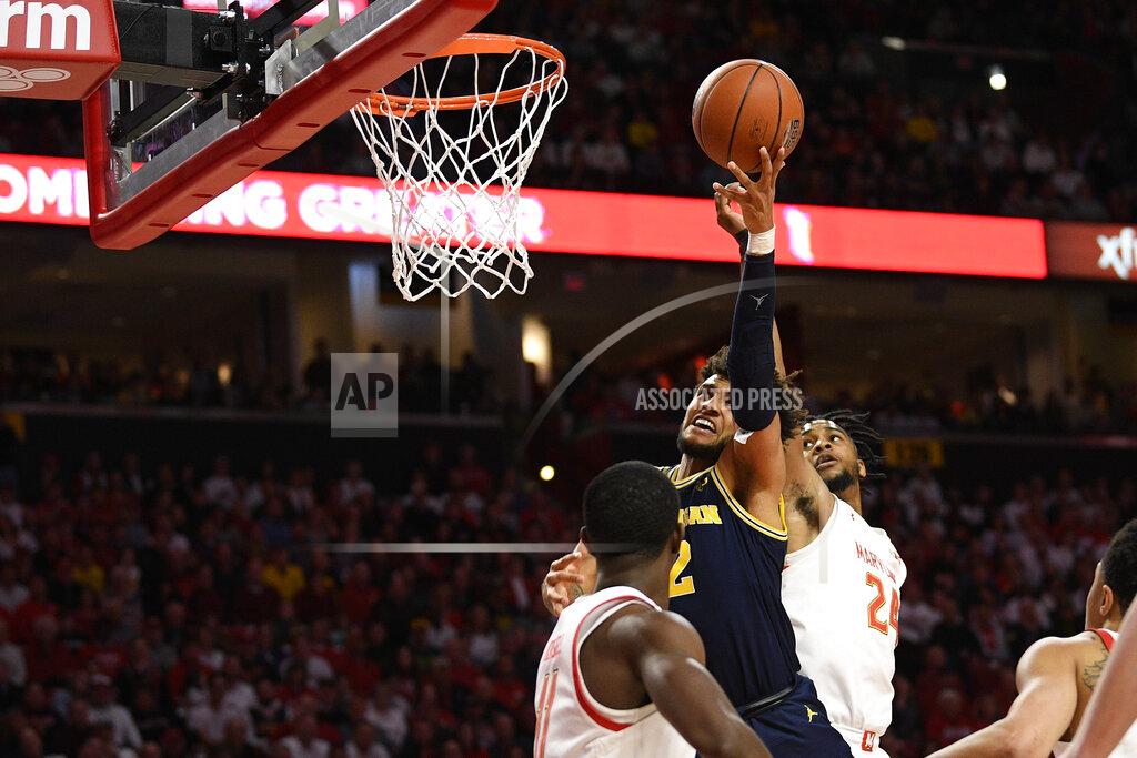 Nick Wass Michigan forward Isaiah Livers (2) goes to the basket between Maryland forward Donta Scott (24) and guard Darryl Morsell (11) during the first half of an NCAA college basketball game, Sunday, March 8, 2020, in College Park, Md. (AP Photo/Nick Wass)