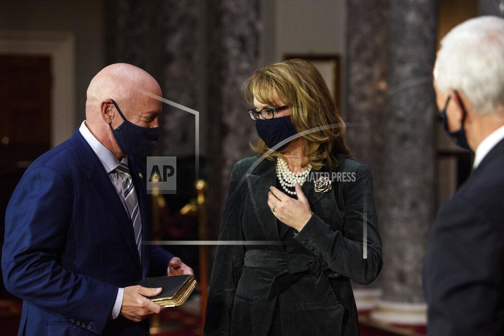 Nicholas Kamm Sen. Mark Kelly, D-Ariz., talks with his wife former Rep. Gabby Giffords, D-Ariz., after participating in a re-enactment of his swearing-in Wednesday, Dec. 2, 2020, by Vice President Mike Pence in the Old Senate Chamber on Capitol Hill in Washington. (Nicholas Kamm/Pool via AP)
