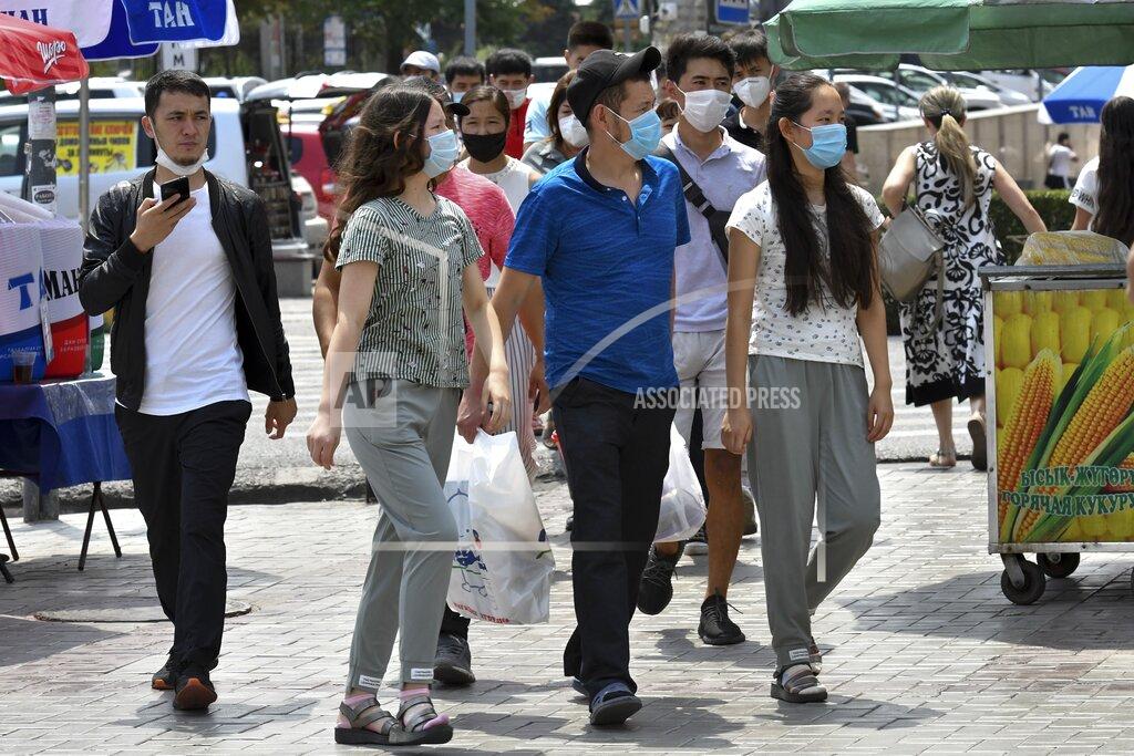 Vladimir Voronin Youths in face masks walk through a street market in Bishkek, Kyrgyzstan, Friday, July 24, 2020. Coronavirus cases surged in Kyrgyzstan after authorities lifted a tight lockdown in May, overwhelming the health care system. But now thousands of volunteers are helping medical workers in busy hospitals, using cars into makeshift ambulances and finding protective gear, drugs, supplies and equipment. (AP Photo/Vladimir Voronin)