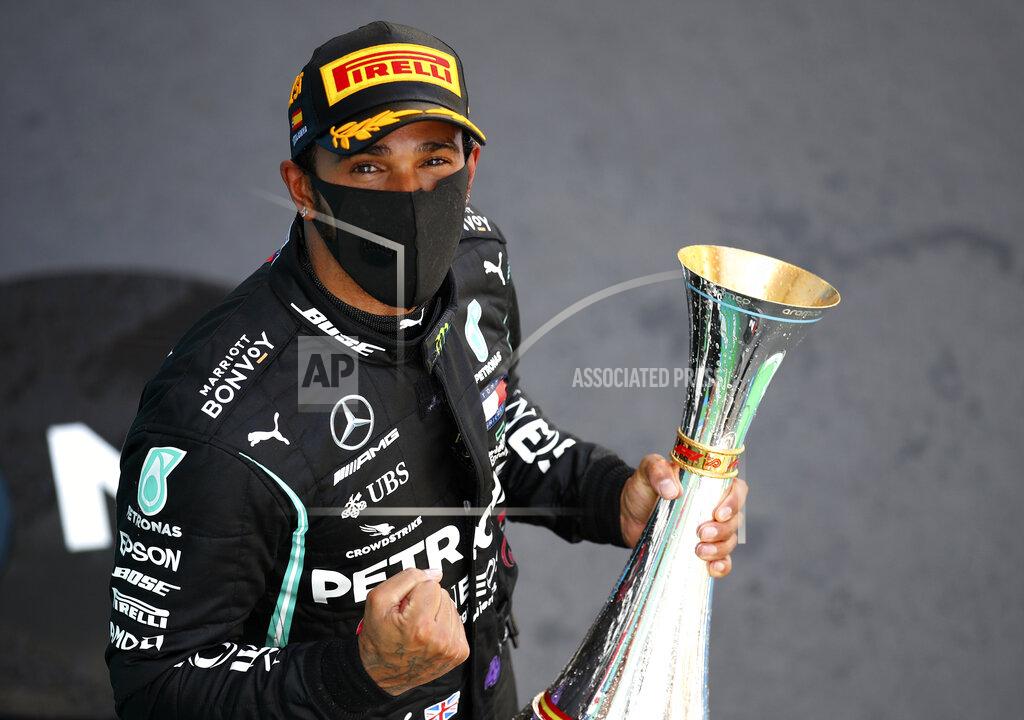 Bryn Lennon Mercedes driver Lewis Hamilton of Britain celebrates on the podium after winning the Formula One Grand Prix at the Barcelona Catalunya racetrack in Montmelo, Spain, Sunday, Aug. 16, 2020. (Bryn Lennon, Pool via AP)