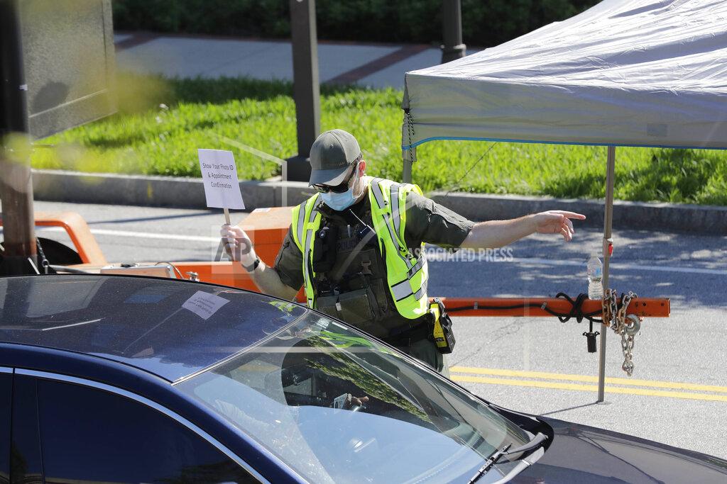 Brynn Anderson An official guides patients to a COVID-19 testing area on Georgia Tech's campus, Monday, April 6, 2020, in Atlanta. (AP Photo/Brynn Anderson)
