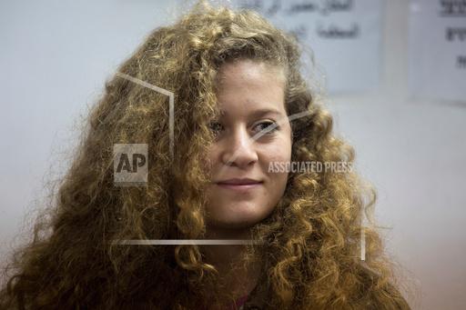 FILE - In this Feb. 13, 2018 file photo, Palestinian activist Ahed Tamimi stands inside the Ofer military prison near Jerusalem. Israeli authorities arrested Tamimi this week for online speech that her family insists wasn't hers. Israeli authorities say that Tamimi is suspected of incitement to terrorism for an Instagram post under her account. (AP Photo/Ariel Schalit, File)