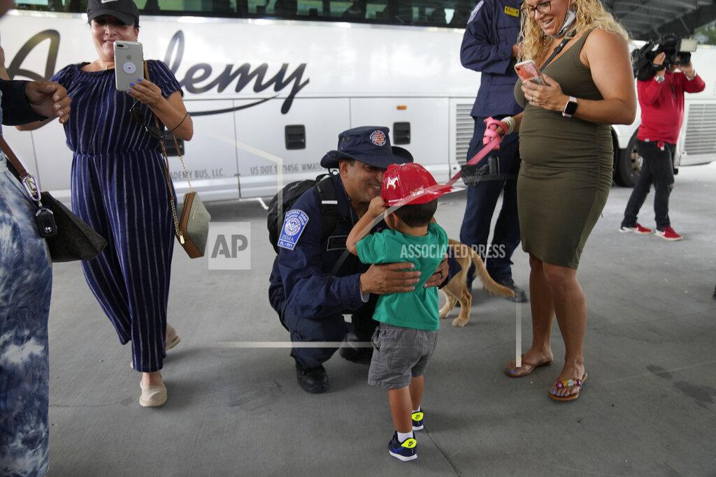 Rebecca Blackwell Enrique Calvo greets his son Enrique, 2, as his wife Joceline looks on, as members of Miami-Dade Fire Rescue's urban search and rescue team are reunited with their families after weeks of working on the rubble pile at the collapsed Champlain Towers South condominium, on Friday, July 23, 2021, in Doral, Fla. (AP Photo/Rebecca Blackwell)