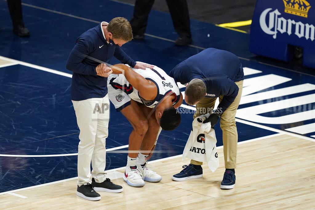 Darron Cummings Gonzaga coach Mark Few, left, helps Jalen Suggs (1) as he is examined during the first half of the team's NCAA college basketball game against West Virginia, Wednesday, Dec. 2, 2020, in Indianapolis. (AP Photo/Darron Cummings)